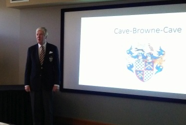 Sir John Cave-Browne-Cave standing beside screen