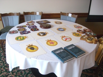 many ships' badges displayed on a table